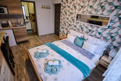 a bedroom with a bed with blue pillows on it at Silver Apartman in Eger