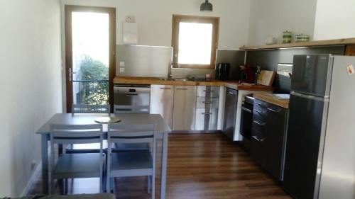 a kitchen with a table and a black refrigerator at La Bouriotte in Labastide-Rouairoux