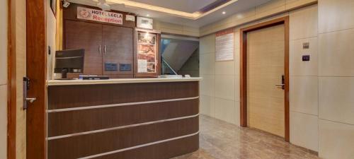 カリヤーンにあるHotel Leelaのドアとテレビ付きのバーのある部屋
