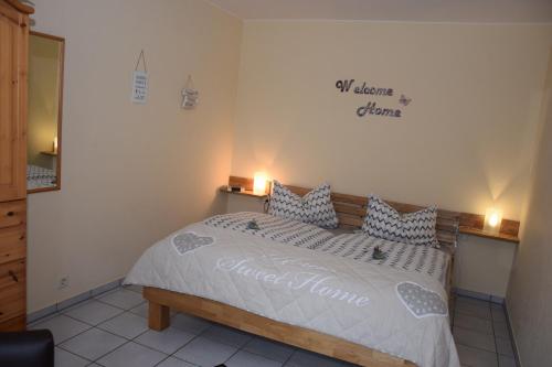 een slaapkamer met een bed met een bord aan de muur bij Haus Luzia in Sankt Aldegund