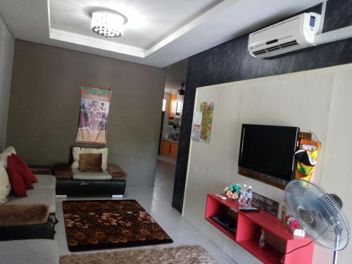 a living room with a couch and a flat screen tv at GERIK BANDING HOMESTAY in Gerik