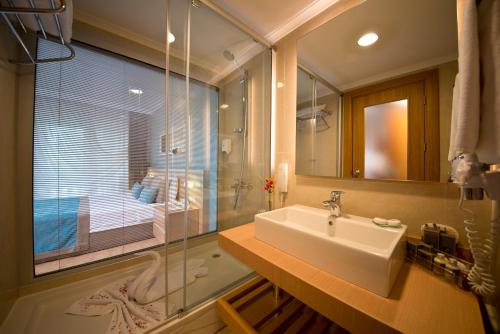 
a bathroom with a tub, sink, and shower at Limak Limra Hotel & Resort Kemer - Kids Concept in Kemer
