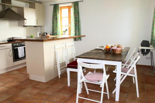 Saliterhof في Warngau: مطبخ مع طاولة وكراسي في مطبخ