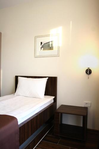 a small room with a bed and a table at Hotel DOA in Skopje