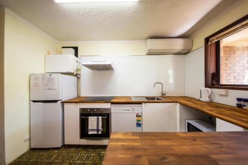 a kitchen with white appliances and a wooden counter top at Leski Club in Jindabyne