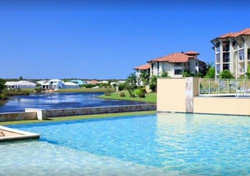a swimming pool in a villa with blue water at Pelican Waters Resort in Caloundra