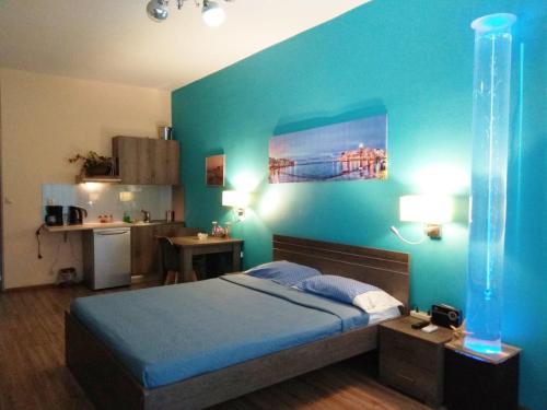 une chambre avec un lit et un mur bleu dans l'établissement Blue Studios, à La Canée