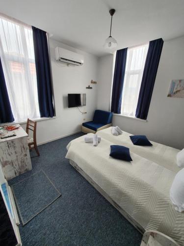 a bedroom with a large bed with blue pillows at Guest House Gurkov in Veliko Tŭrnovo