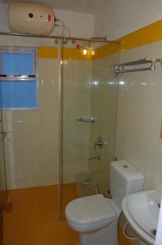 a bathroom with a shower and a toilet and a sink at Altius Nest Hotel in Kodaikānāl
