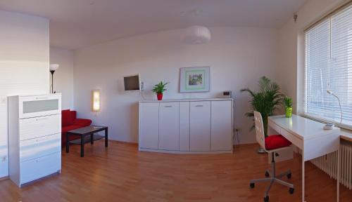 a living room with a desk and a red chair at Apartment Bad Reichenhall in Bad Reichenhall