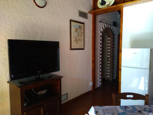 a living room with a flat screen tv on a stand at Liliana Home Beach in Fontane Bianche