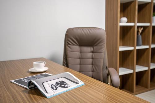 a table with a book and a cup and a chair at Home Fourest Residence Hotel Okpo in Geoje 
