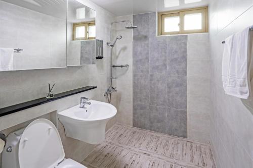 ein weißes Bad mit einem Waschbecken und einem WC in der Unterkunft Home Fourest Residence Hotel Okpo in Geoje