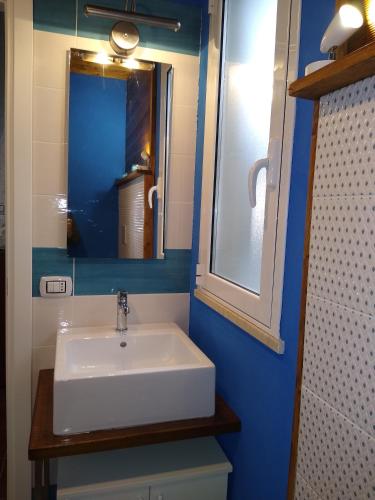 a bathroom with a white sink and a mirror at Liliana Home Beach in Fontane Bianche