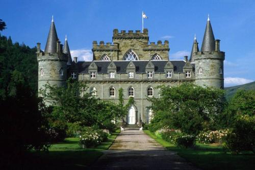 an old castle with a flag on top of it at The Curling Pond, Dalmally Road, Inveraray in Inveraray
