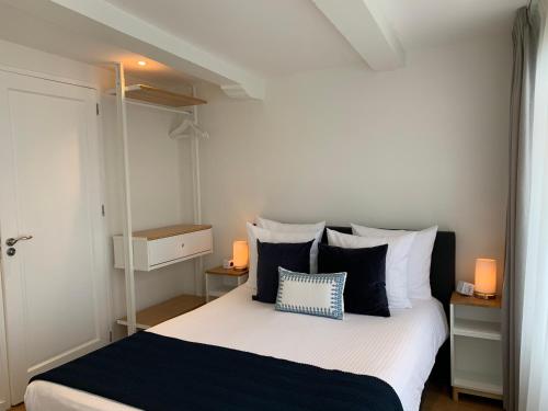 una camera da letto con un letto con cuscini bianchi e neri di PH93 Amsterdam Central ad Amsterdam