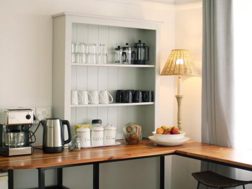 a kitchen counter with a coffee maker and a bowl of fruit at At The Loerie in Knysna
