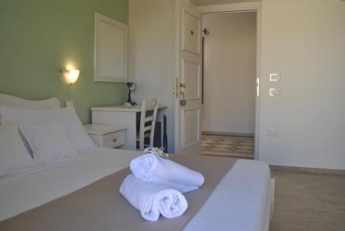 ein Schlafzimmer mit einem weißen Bett und Handtüchern darauf in der Unterkunft Hotel Stella D'Oro in Villasimius