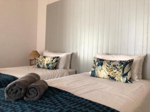 a bedroom with two beds with towels on them at At The Loerie in Knysna