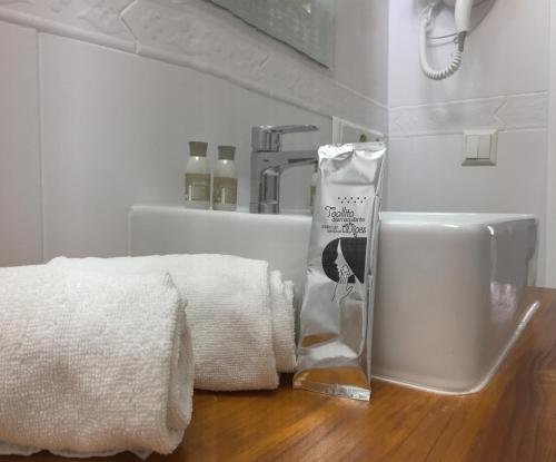 a bathroom with a sink and towels on a wooden floor at Apartamentos Baiti Ronda in Ronda