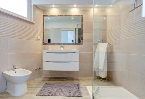 a bathroom with a toilet and a sink and a mirror at Vila Gaivota 3G in Ferragudo