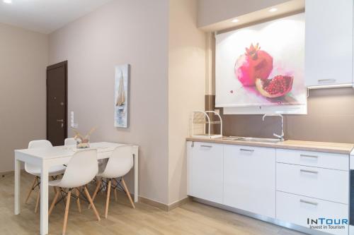 a kitchen with a table and white cabinets and a window at Chic and Minimal apartment close to Thissio Metro in Athens