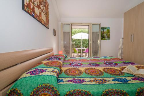 a bedroom with a large bed with a book on it at House Rita Marzamemi in Marzamemi