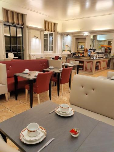 a restaurant with tables and chairs and a laptop computer at Best Western Central Hotel in Tours