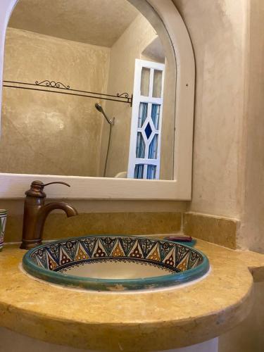 a bathroom counter with a sink and a mirror at Casa Perleta in Chefchaouene