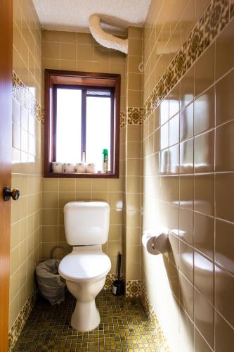 a bathroom with a toilet and a window at Leski Club in Jindabyne