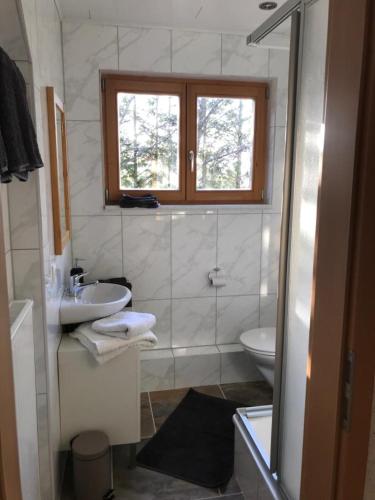a white bathroom with a sink and a toilet at Haus Kleewiese in Ulmen