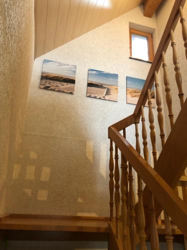 eine Treppe mit drei Gemälden an der Wand in der Unterkunft Haus Kleewiese in Ulmen