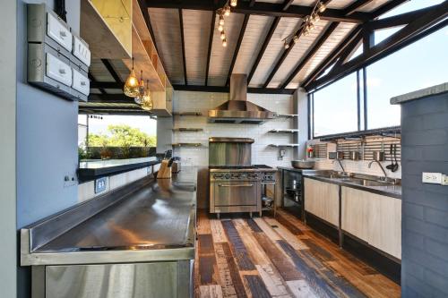 a large kitchen with stainless steel appliances and windows at International House Co-Living in Medellín