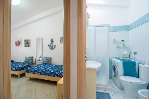 a bathroom with two beds and a toilet and a sink at House Rita Marzamemi in Marzamemi