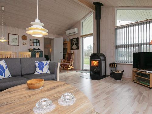een woonkamer met een bank en een houtkachel bij 7 person holiday home in Hj rring in Hjørring