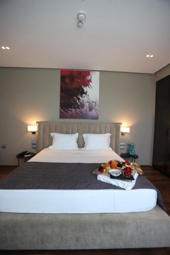 a bedroom with a large bed with a tray of food on it at Supreme Hotel in Golem