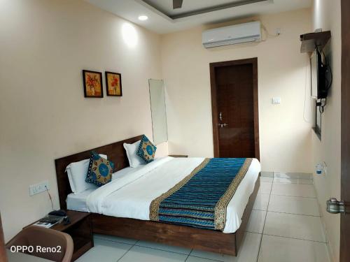 a bedroom with a large bed in a room at Amrit Hotel, Bhopal in Bhopal