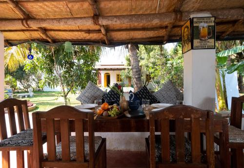 a table with a bowl of fruit on top of it at The Hammock Goa in Anjuna