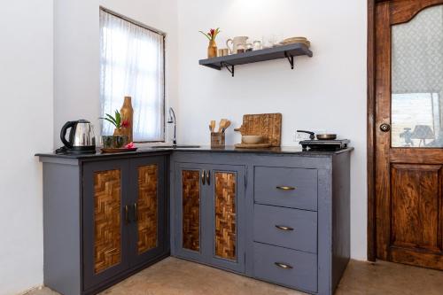 a kitchen with a blue cabinet and a window at The Hammock Goa in Anjuna