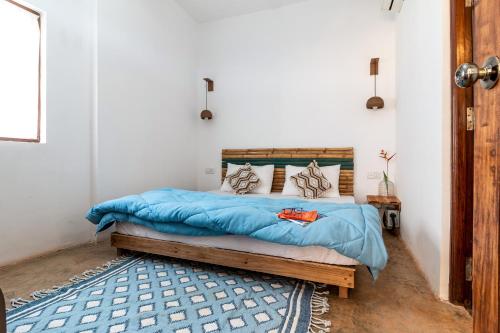 a bedroom with a bed with a blue comforter at The Hammock Goa in Anjuna
