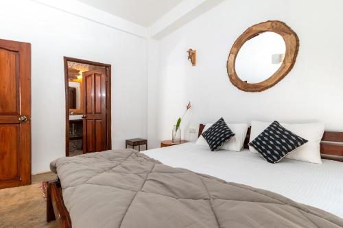 a bedroom with a bed and a mirror on the wall at The Hammock Goa in Anjuna