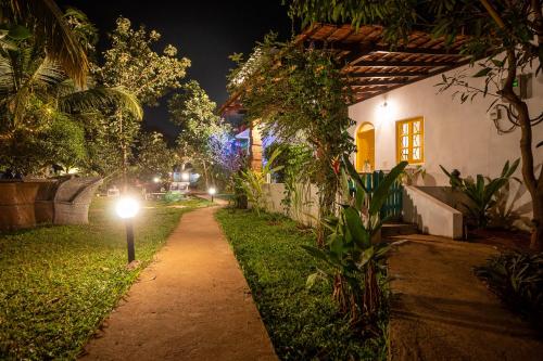a pathway in front of a house at night at The Hammock Goa in Anjuna