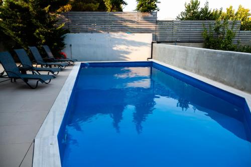 a swimming pool with blue water in a backyard at Seaview Pool Villa near Beach and Athens Airport in Porto Rafti