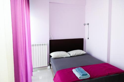 a bedroom with a bed with pink and grey sheets at Seaview Pool Villa near Beach and Athens Airport in Porto Rafti