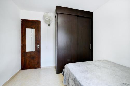a bedroom with a wooden door and a bed at International House Co-Living in Medellín