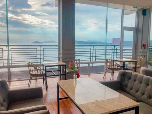 a room with tables and chairs and a view of the water at Hotel Hue Loft in Incheon