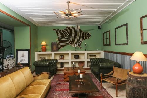 a living room with couches and a zebra on the wall at Casa Colonial Koenig in São Filipe