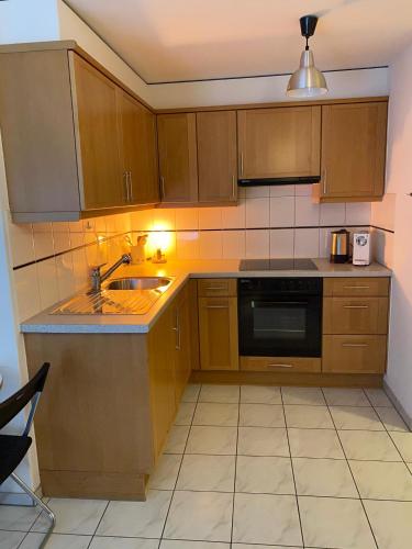 a kitchen with wooden cabinets and a sink at Studio Brunnmatt in Zermatt