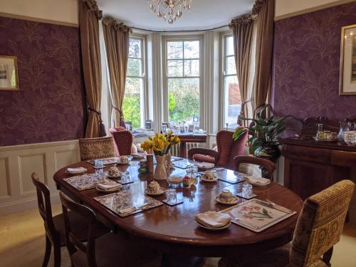 comedor con mesa de madera y sillas en St Katharine's House en Milford Haven