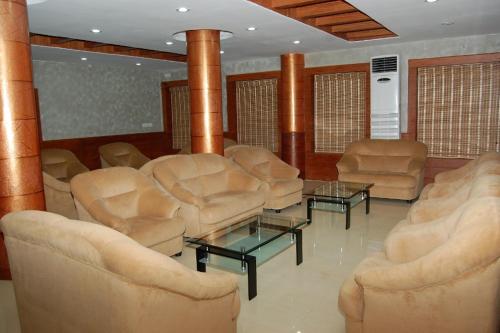 a living room with chairs and tables and columns at KPM Regency in Palakkad